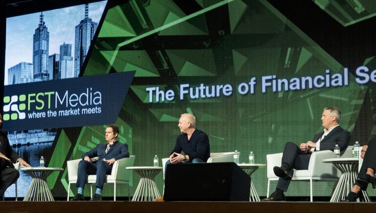 Panelists on stage at a financial services conference with the FST Media backdrop.