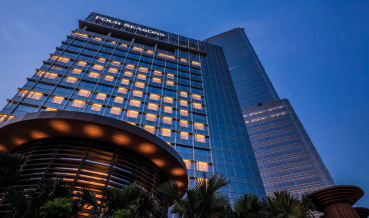 Twilight view of the illuminated Four Seasons hotel with modern architecture.